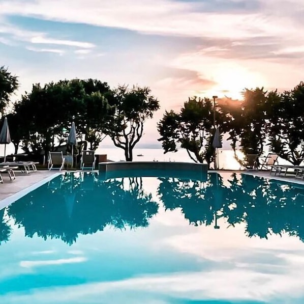 Outdoor pool, open 8:00 AM to 8:00 PM, pool umbrellas, pool loungers