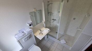 A modern bathroom with a shower, toilet, and sink.