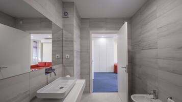 Un baño moderno con una bañera grande, un lavamanos y un bidé.