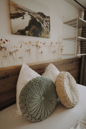 A bed with three pillows, a wooden headboard, and a wall-mounted picture of a landscape. - Parkhotel Brunauer (Salzburg)