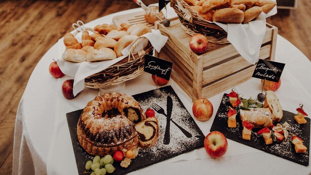 Una mesa de buffet con diversos alimentos y una cocina al fondo.