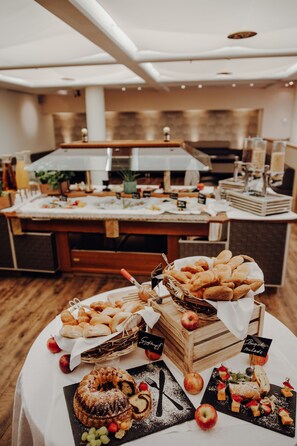 Una mesa de buffet con diversos alimentos y una cocina al fondo.