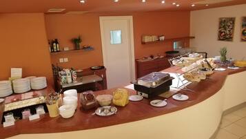 A buffet setup with various food items and utensils.