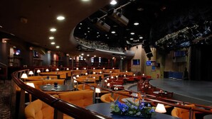 A theater with multiple seating levels, a stage, and a buffet area with tables and chairs. - Perla, Resort & Entertainment (Nova Gorica)