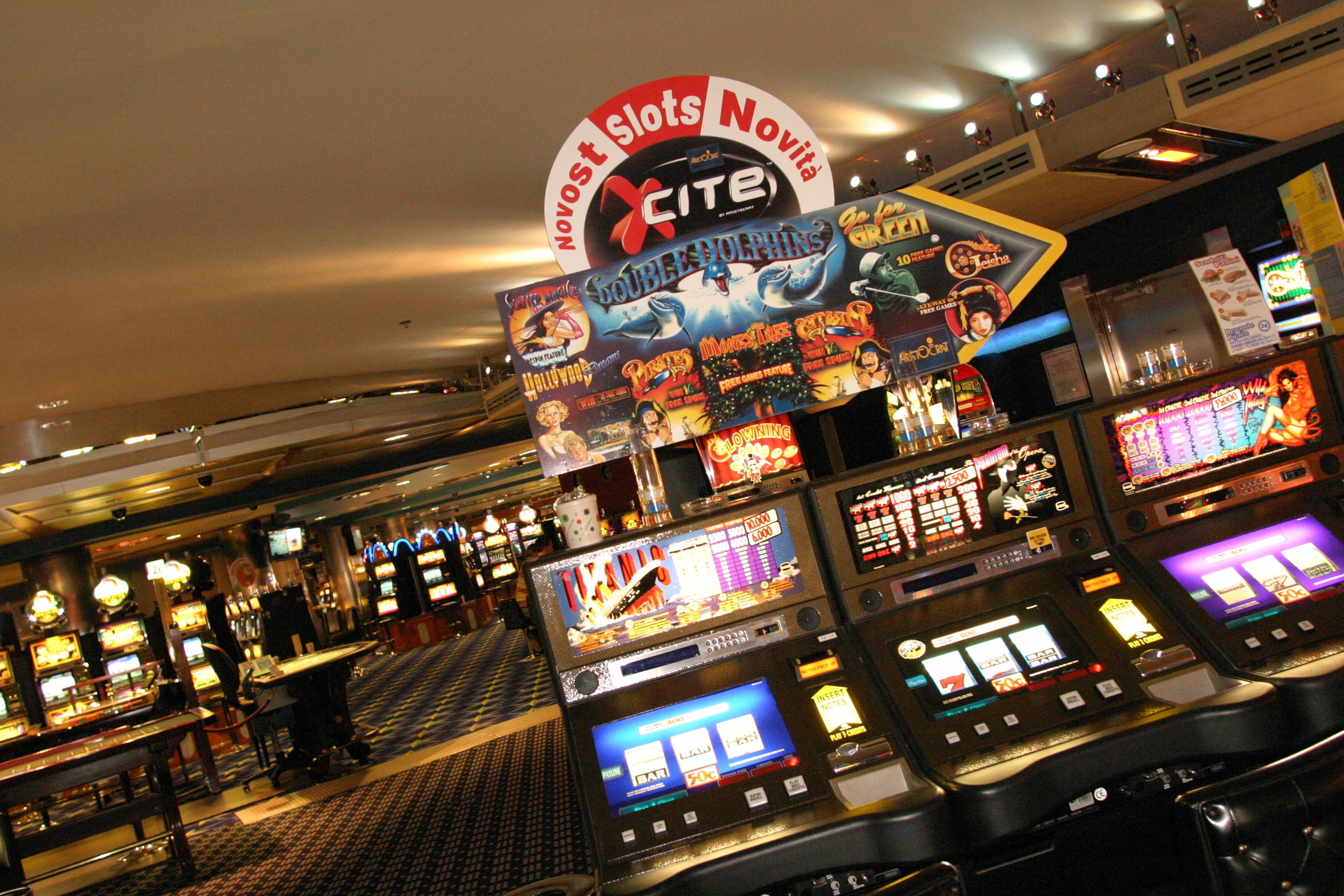 Ein Casino mit Spielautomaten und einem Neon-Schild, das 'Novost Slots Novita' bewirbt.
