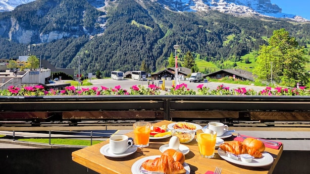A table with breakfast items and a mountain view. - Hotel Bernerhof Grindelwald (Grindelwald)