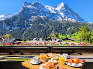 Una mesa con alimentos para el desayuno y vistas a la montaña.