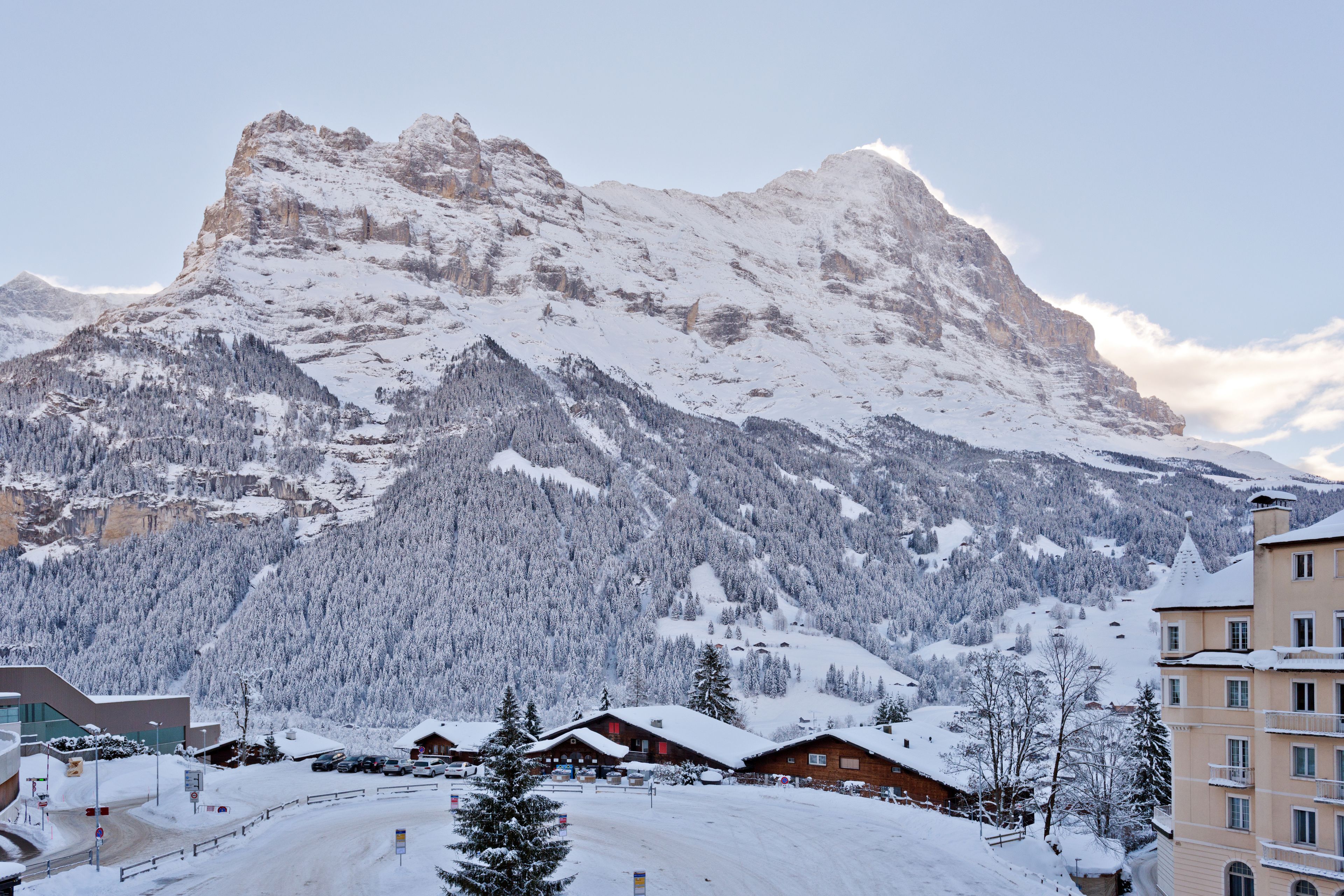 A mountain resort with snow-covered buildings and a prominent peak in the background.