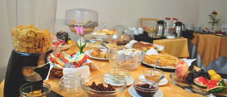 A buffet table with various food items and a coffee maker.