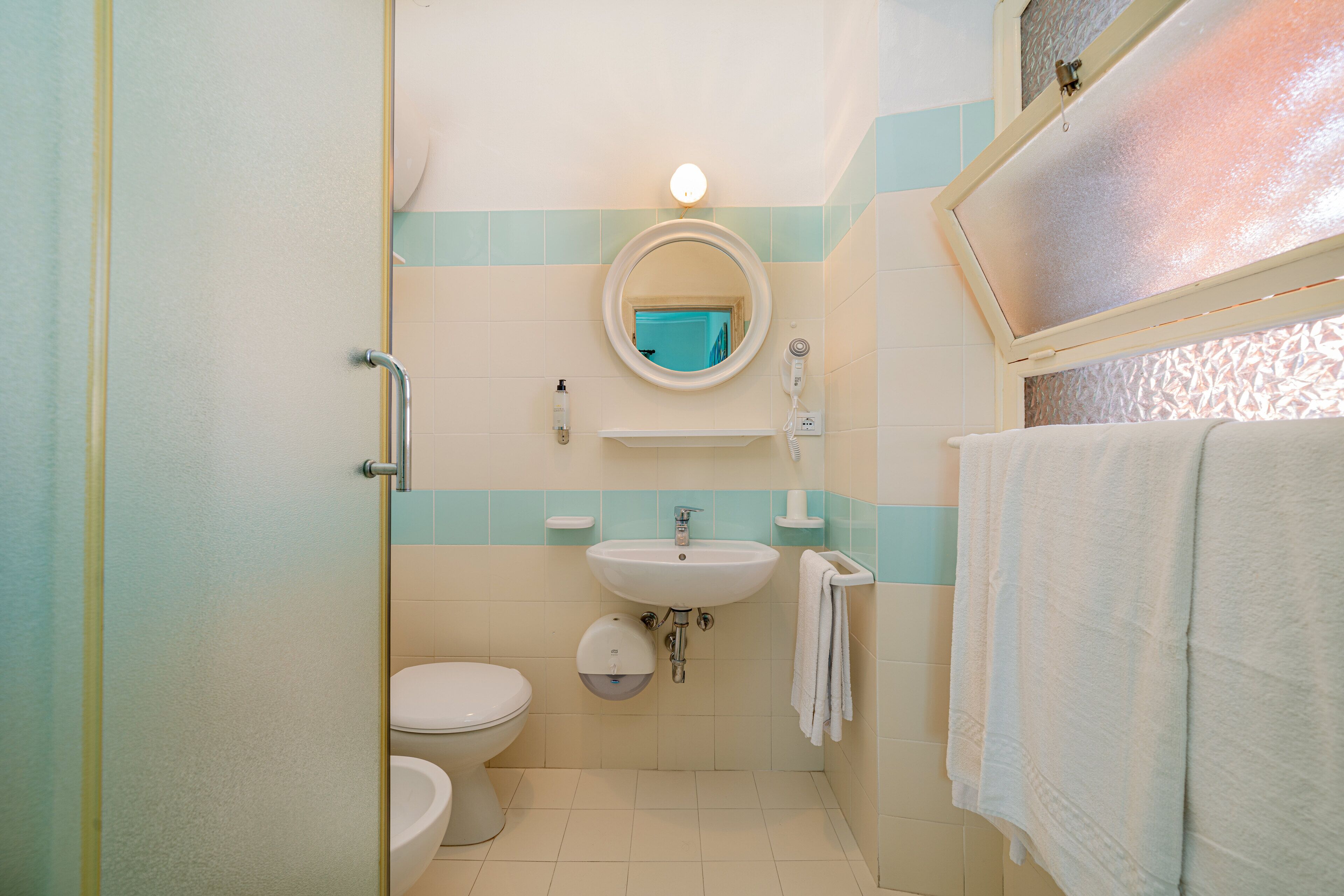 Un baño con inodoro, lavabo y espejo.