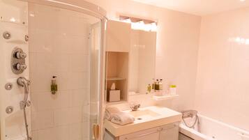 Un bagno moderno con doccia vetrata, un mobile lavabo e una vasca da bagno.