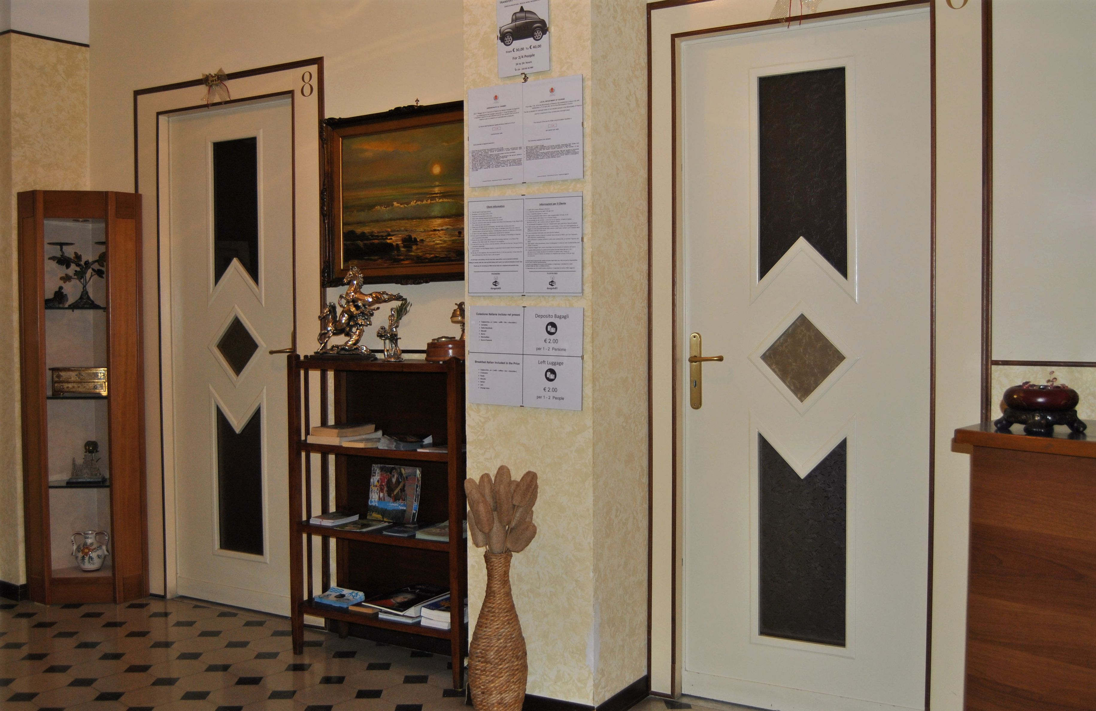 Un pasillo con dos puertas, una estantería y un jarrón decorativo.