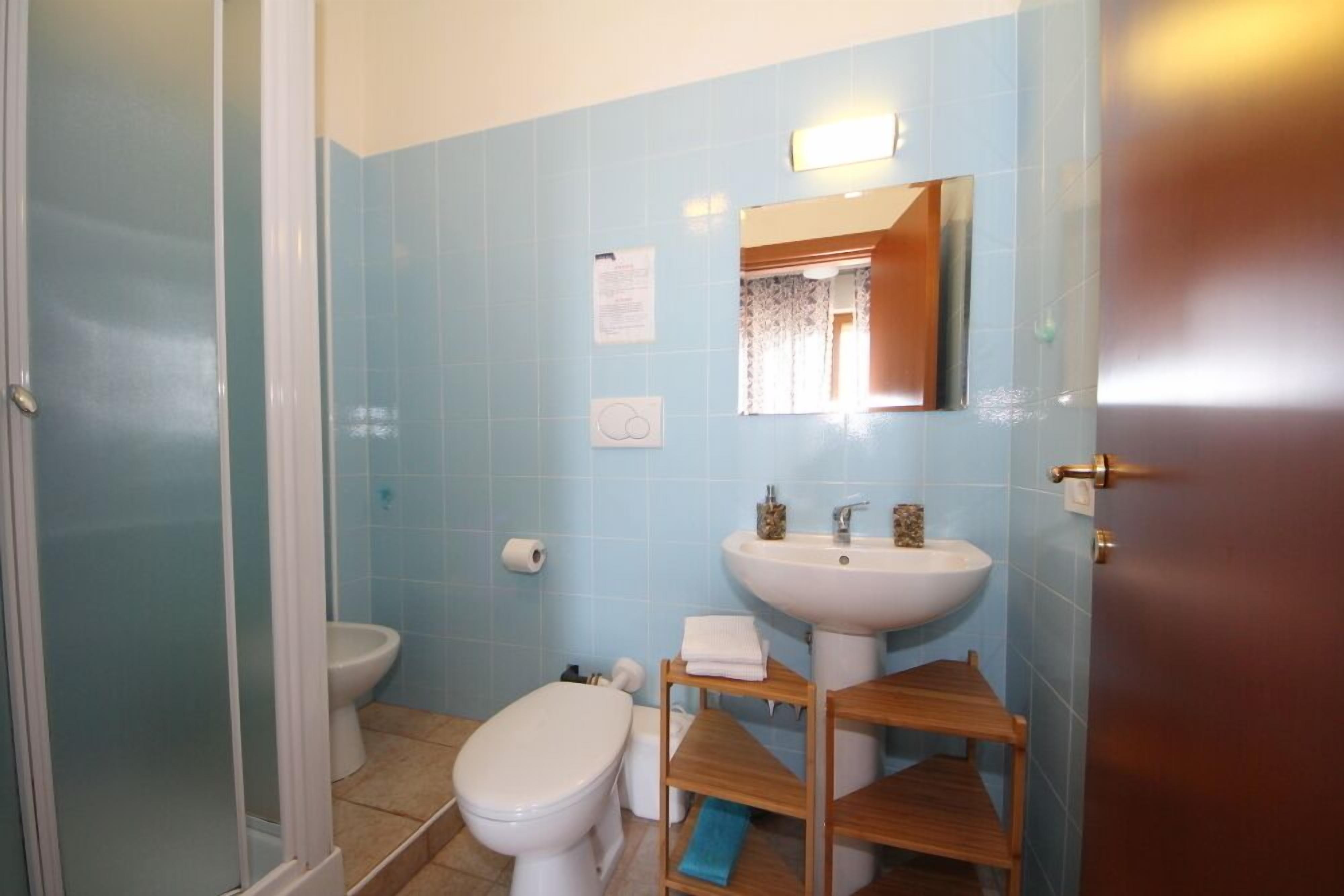 Un baño con inodoro, lavamanos y espejo.