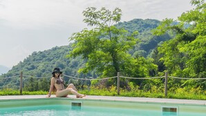 A person sitting by a pool with a mountainous backdrop. - Hotel Mirabeau (Bellagio)