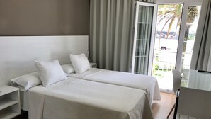 A hotel room with two beds, a desk, and a chair. - Nuevo Vichona (Sanxenxo)