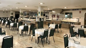 A spacious dining area with multiple tables and chairs, a buffet counter, and a kitchen area. - Nuevo Vichona (Sanxenxo)