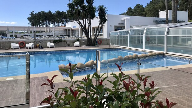 A swimming pool with lounge chairs and a greenhouse structure. - Nuevo Vichona (Sanxenxo)