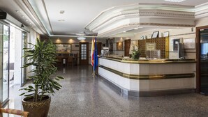 A reception area with a marble counter, a chandelier, and a potted plant. - Nuevo Vichona (Sanxenxo)