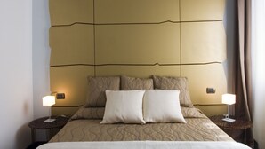 A hotel room with a large bed, two bedside tables, and a headboard with a unique design. - Romeo al Babuino (Rome)