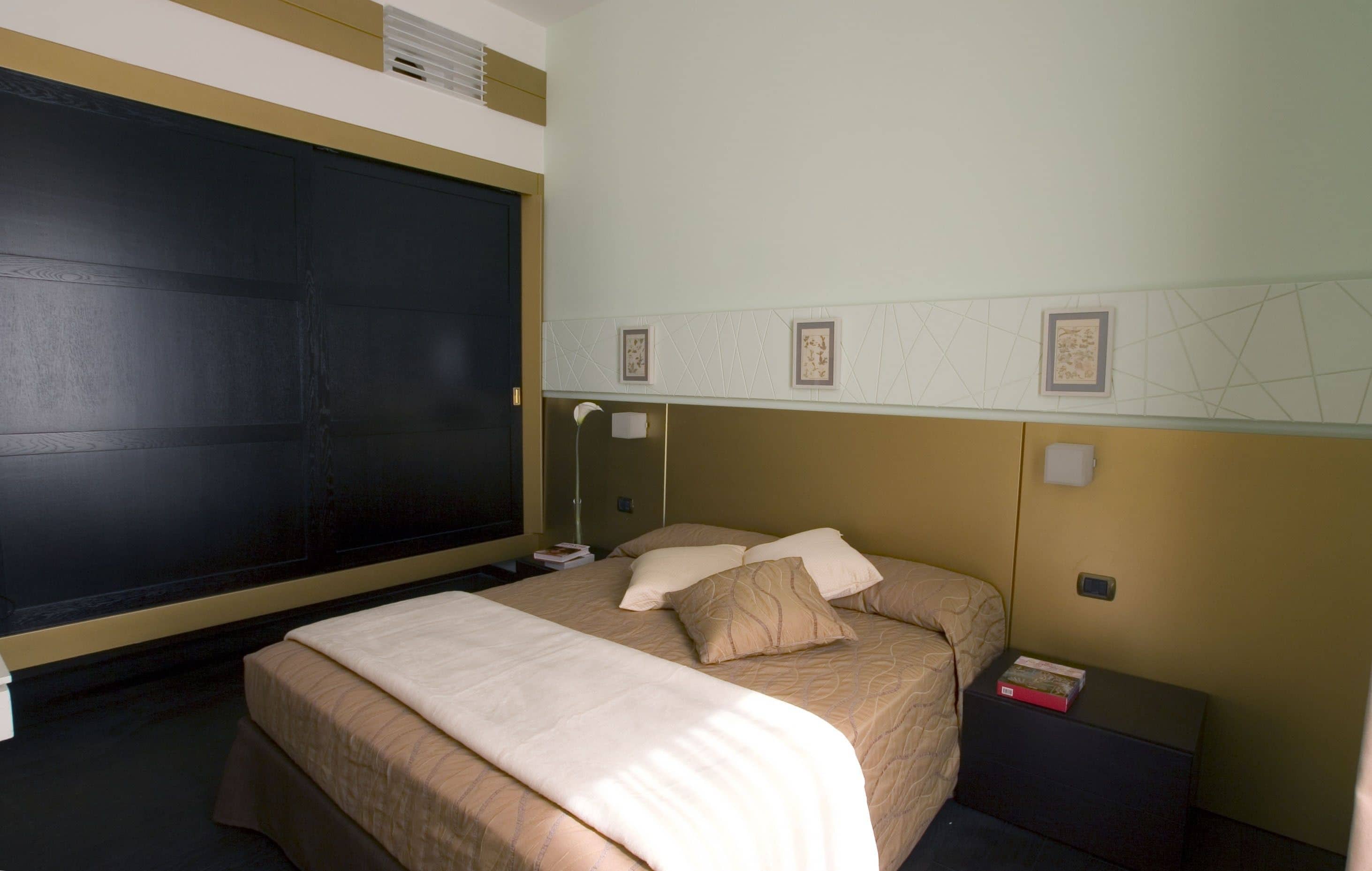 Une chambre d’hôtel avec un grand lit, des tables de chevet, une petite table et un téléviseur fixé au mur.