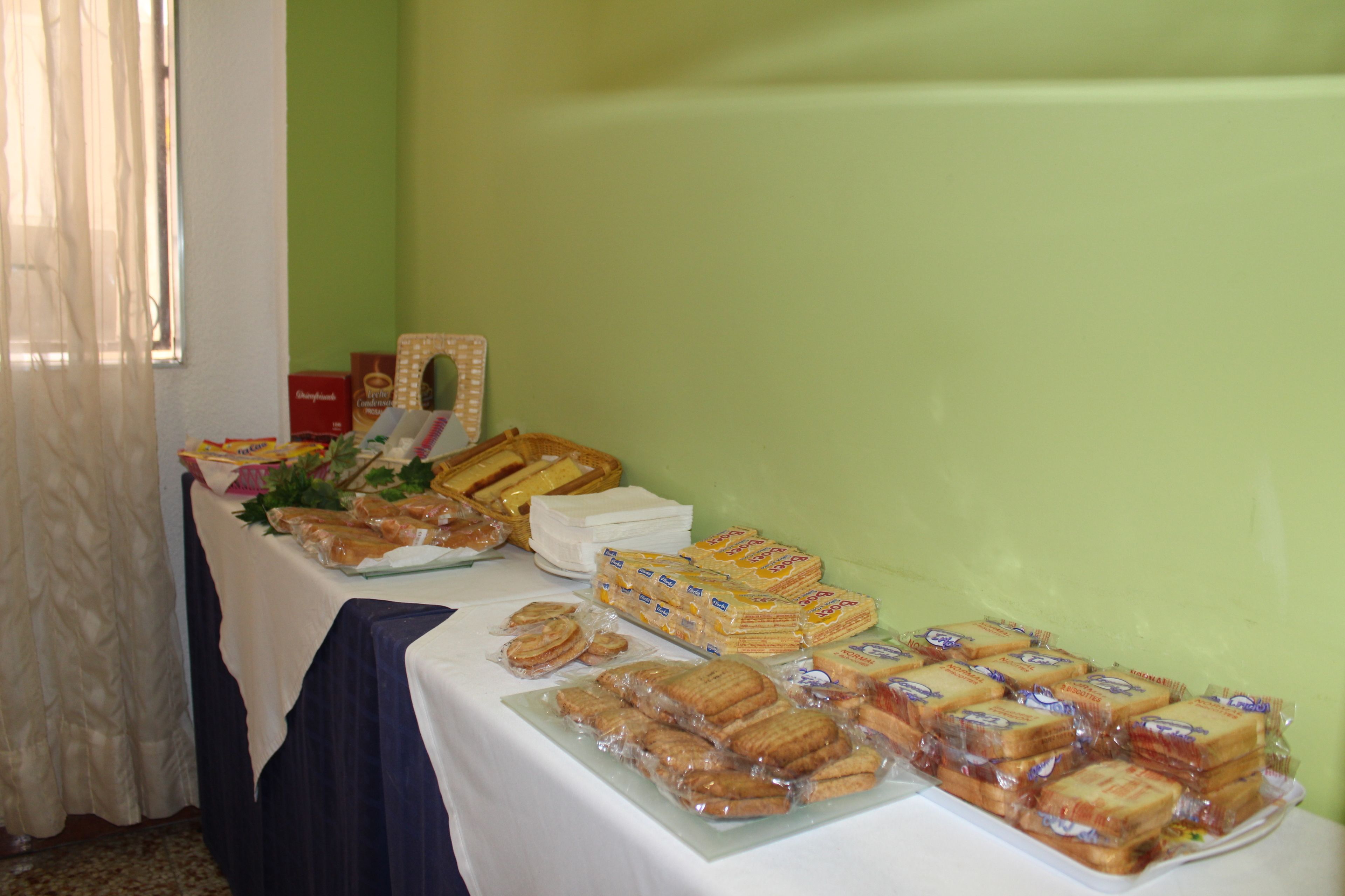 A buffet table with various food items including sandwiches, pastries, and boxed goods.