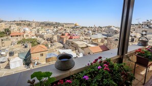 A view of a cityscape with historical architecture, including domed buildings and a prominent golden dome in the distance. - Hashimi Hotel (Jerusalem)