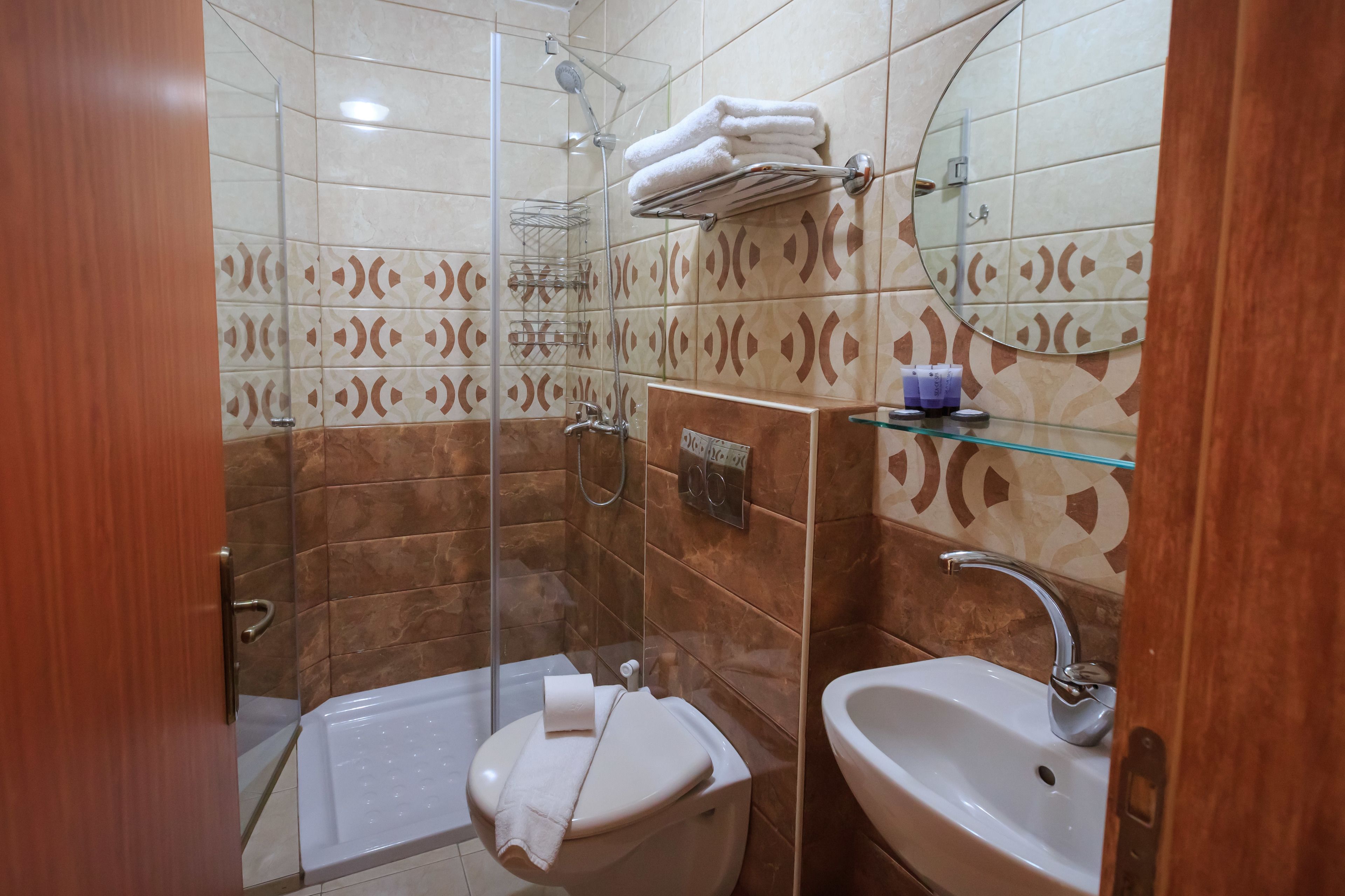 Ein Badezimmer mit Duschkabine, Toilette und Waschbecken.