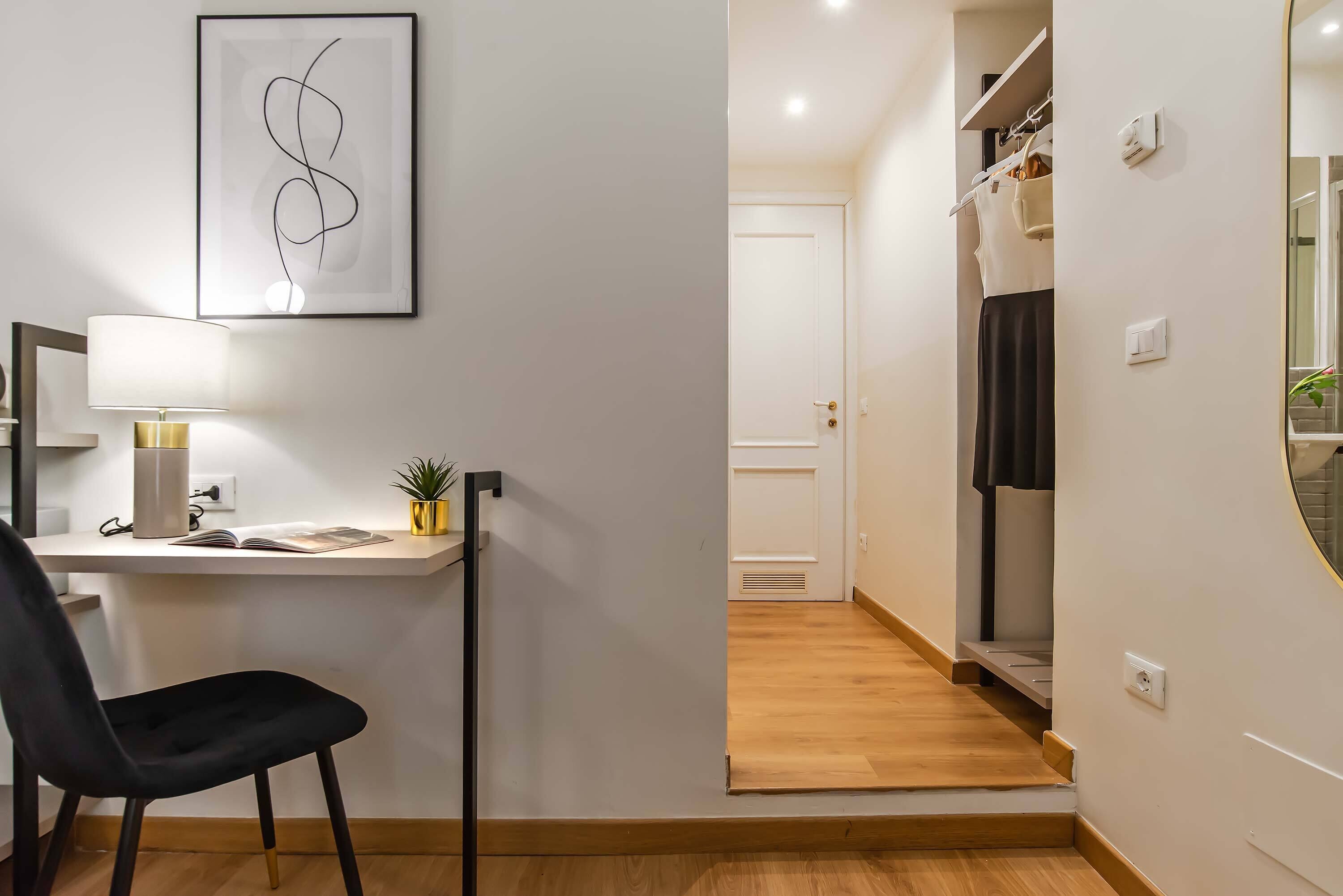A modern room with a desk, chair, and a framed abstract artwork.