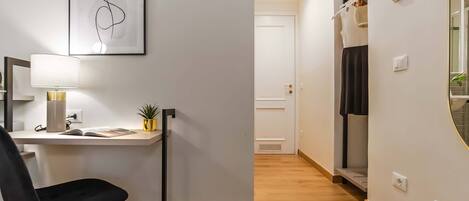 A modern room with a desk, chair, and a framed abstract artwork.