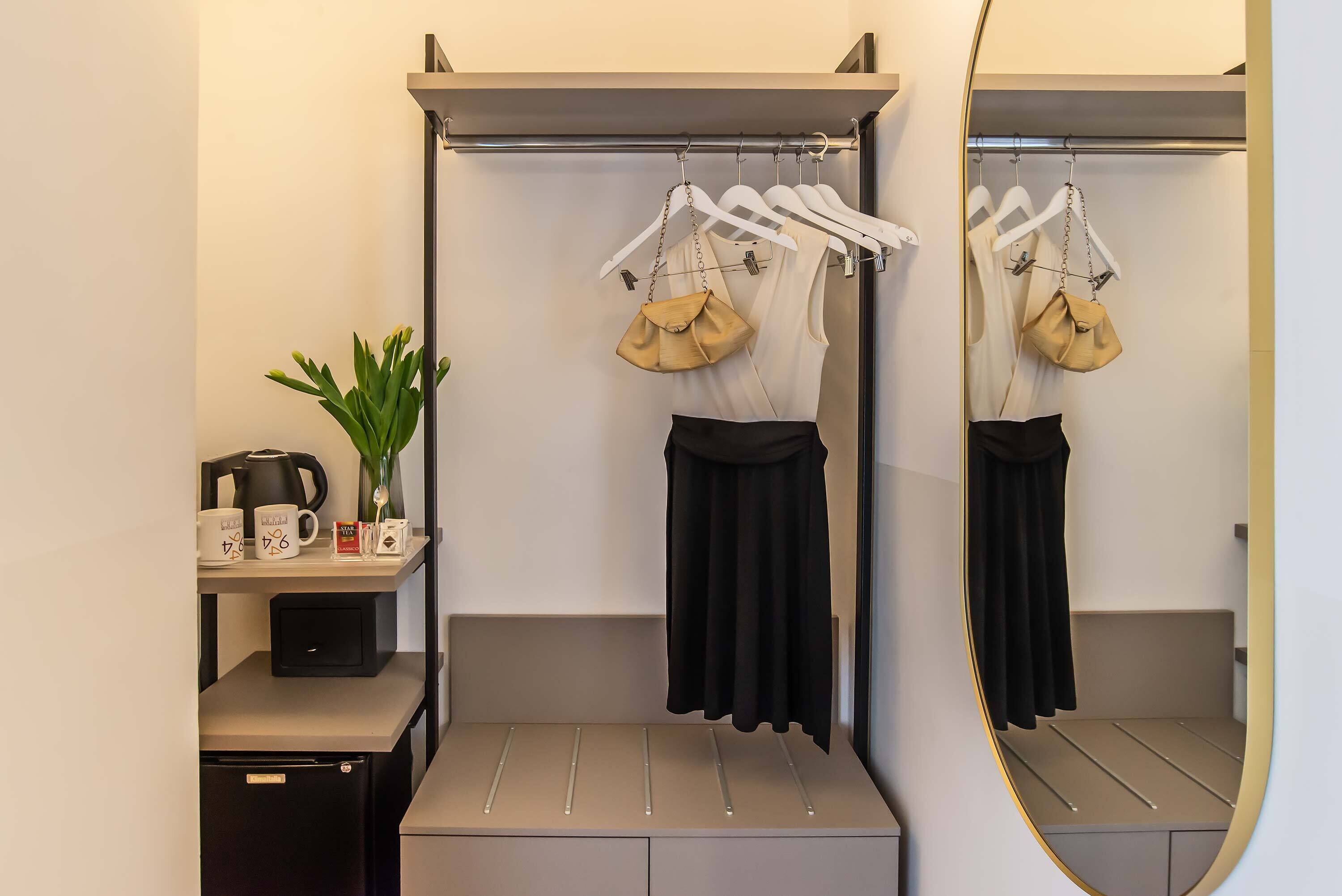 A modern bathroom with a vanity, a mirror, and a hanging rack with bags.