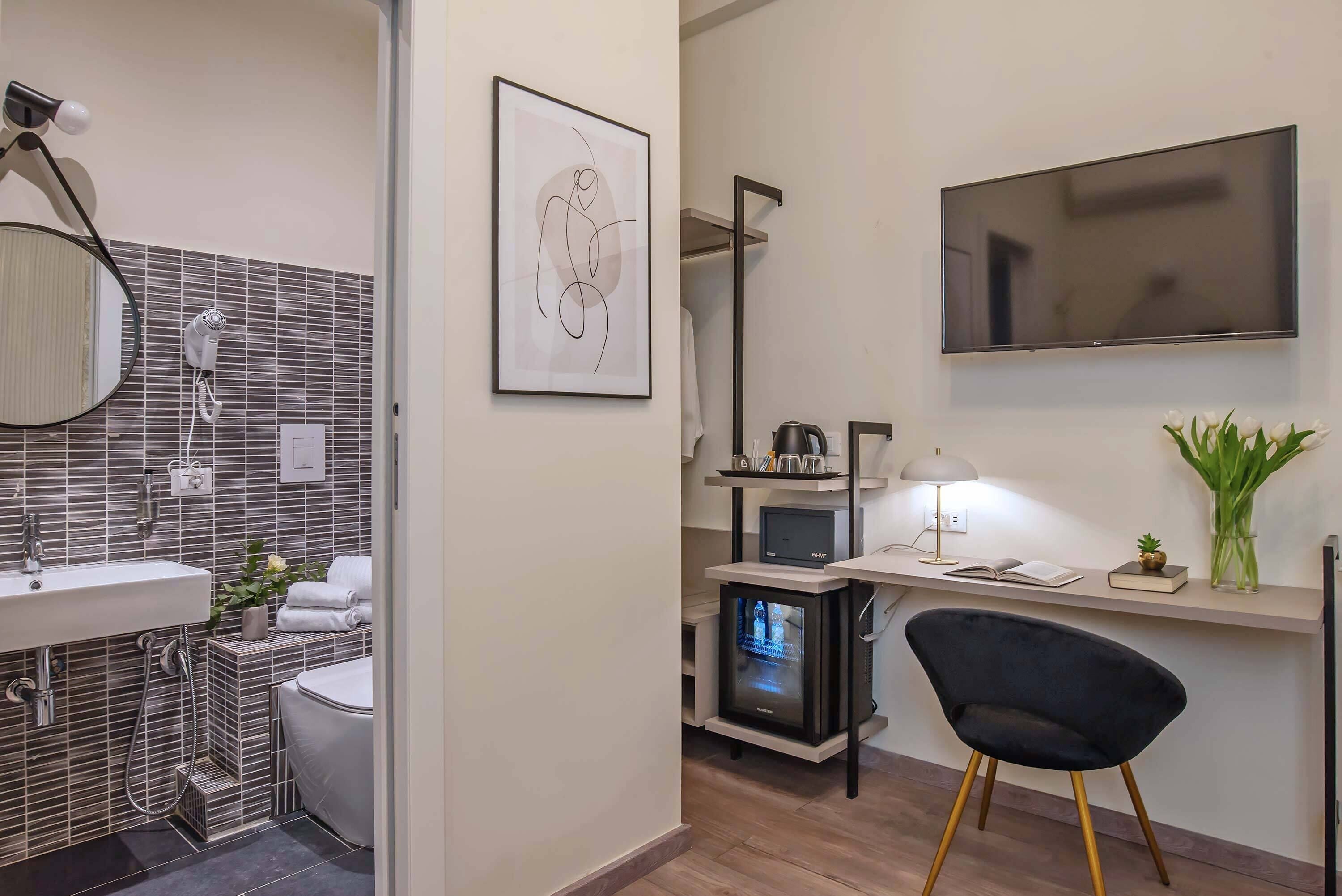 A modern bathroom with a sink, mirror, and towel rack.