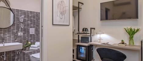 A modern bathroom with a sink, mirror, and towel rack.