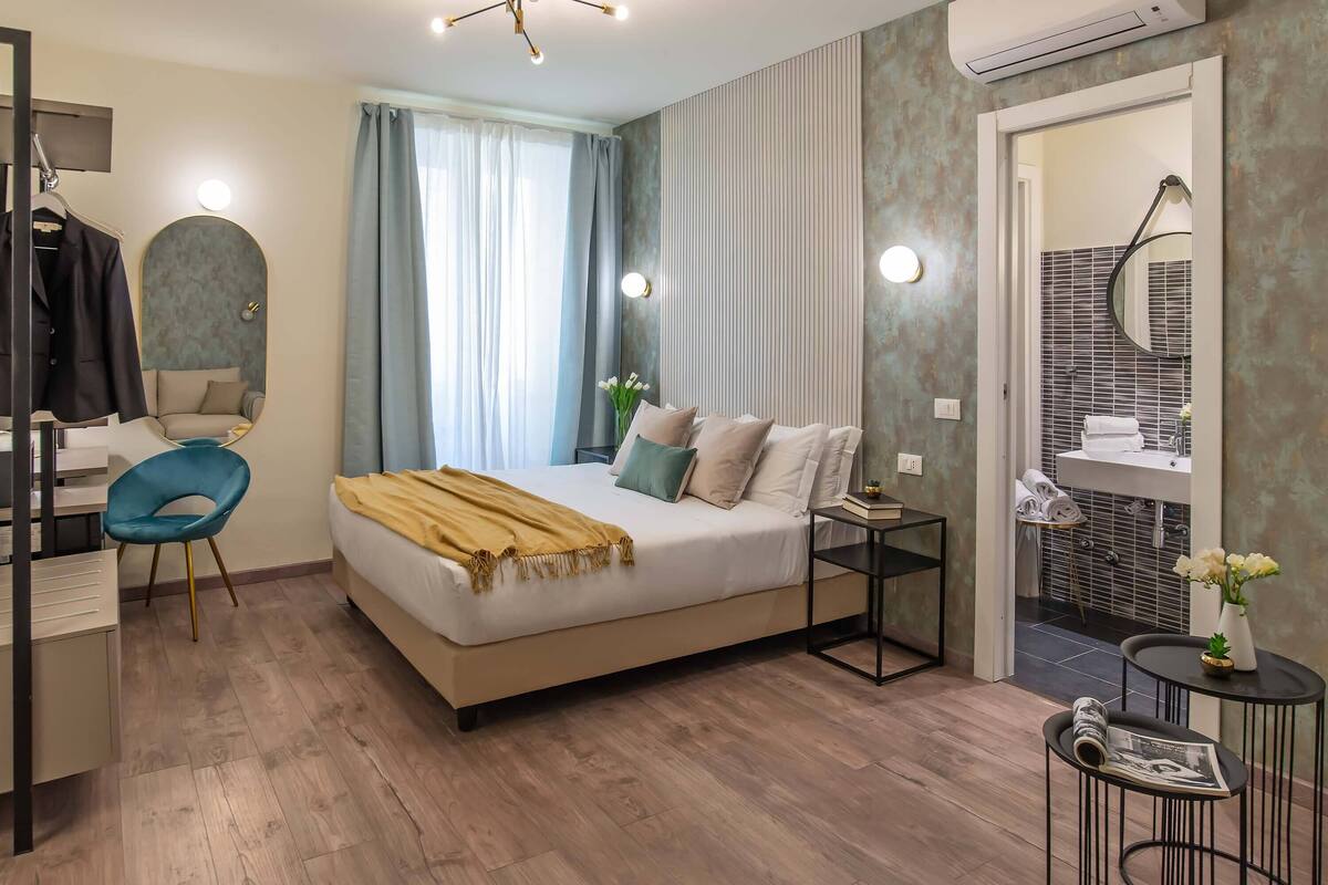 Een moderne slaapkamer met een bed, nachtkastjes, een bureau en een stoel.