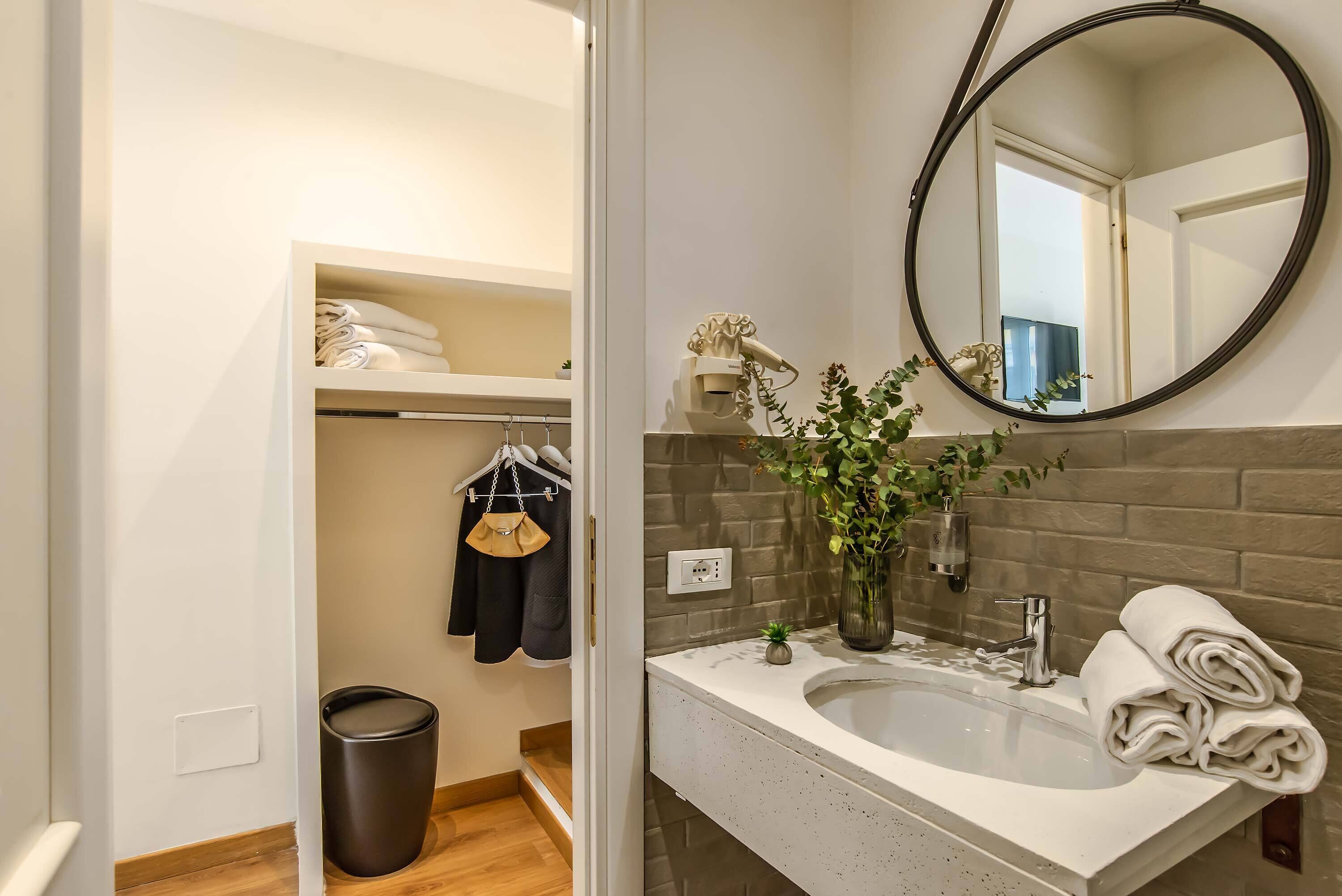 A bathroom with a white sink, a mirror, and a towel rack.