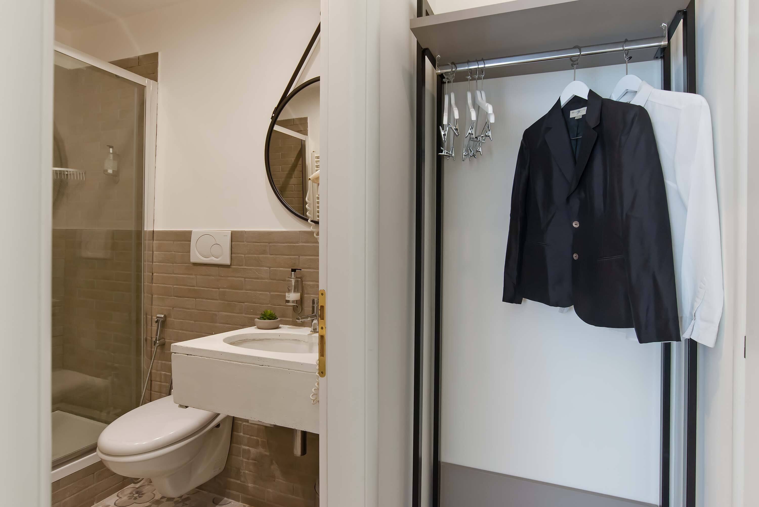 A modern bathroom with a glass-enclosed shower, a white toilet, and a sink with a mirror above it.