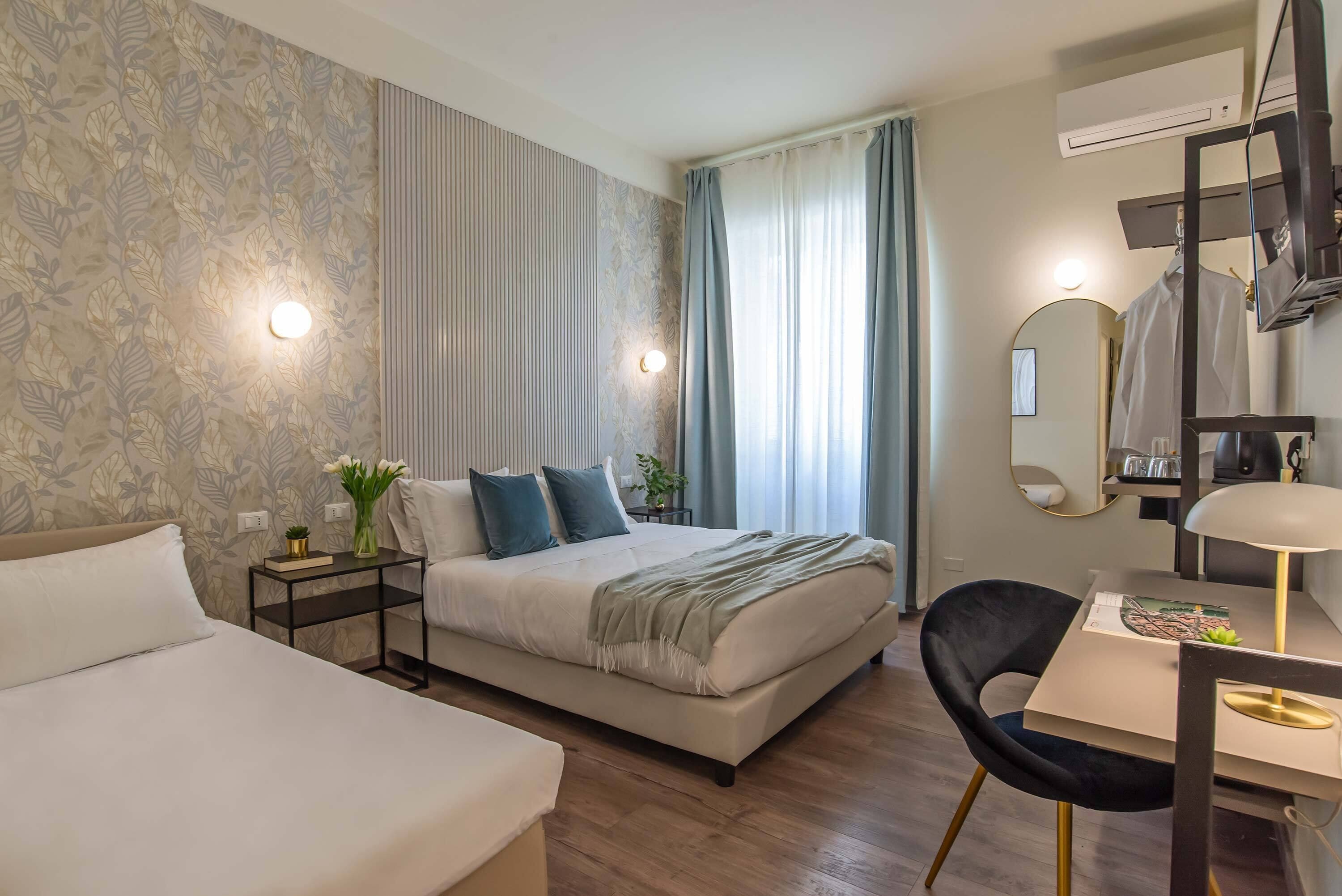 Ein modernes Hotelzimmer mit Bett, Nachttisch, Stuhl und Schreibtisch mit Lampe.