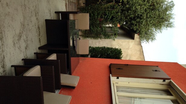 Un espace extérieur aménagé avec des meubles en osier et un tapis rouge.