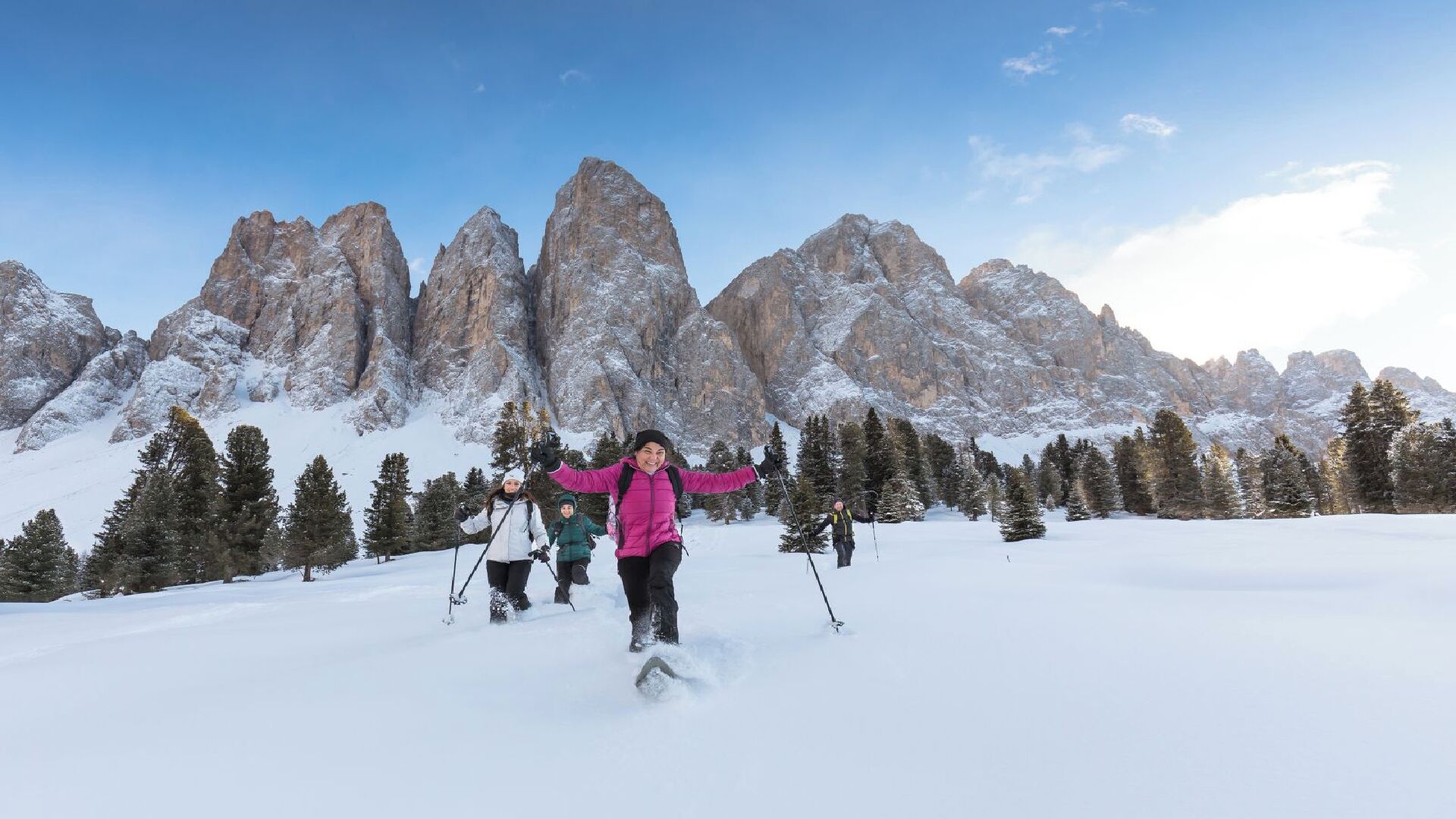 A snowy mountain landscape with skiers.