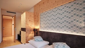 Ein Hotelzimmer mit einer Holzwand, einer Wand mit Muster und einem Bett mit weißer Bettwäsche.