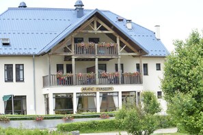 A two-story building with a balcony adorned with flowers, labeled as a hotel, restaurant, and bar. - LOGIS Aranc Evasion (Aranc)