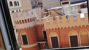 A building with arched windows and balconies, viewed from a window. - San Giovanni in Laterano (Rome)
