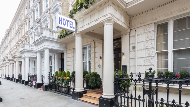A row of white buildings with a sign indicating a hotel. - Notting Hill Gate Hotel (London)