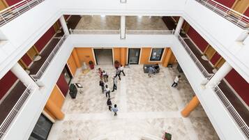 Ein mehrgeschossiges Atrium mit Marmorböden und weißen Geländern.