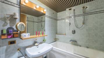 Une salle de bain moderne avec un grand miroir, un lavabo, une baignoire et une douche.