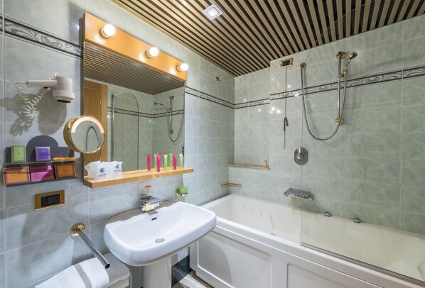 A modern bathroom with a large mirror, a sink, a bathtub, and a shower.