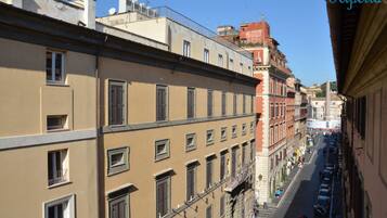 A narrow street with buildings on either side, featuring multiple windows and balconies.