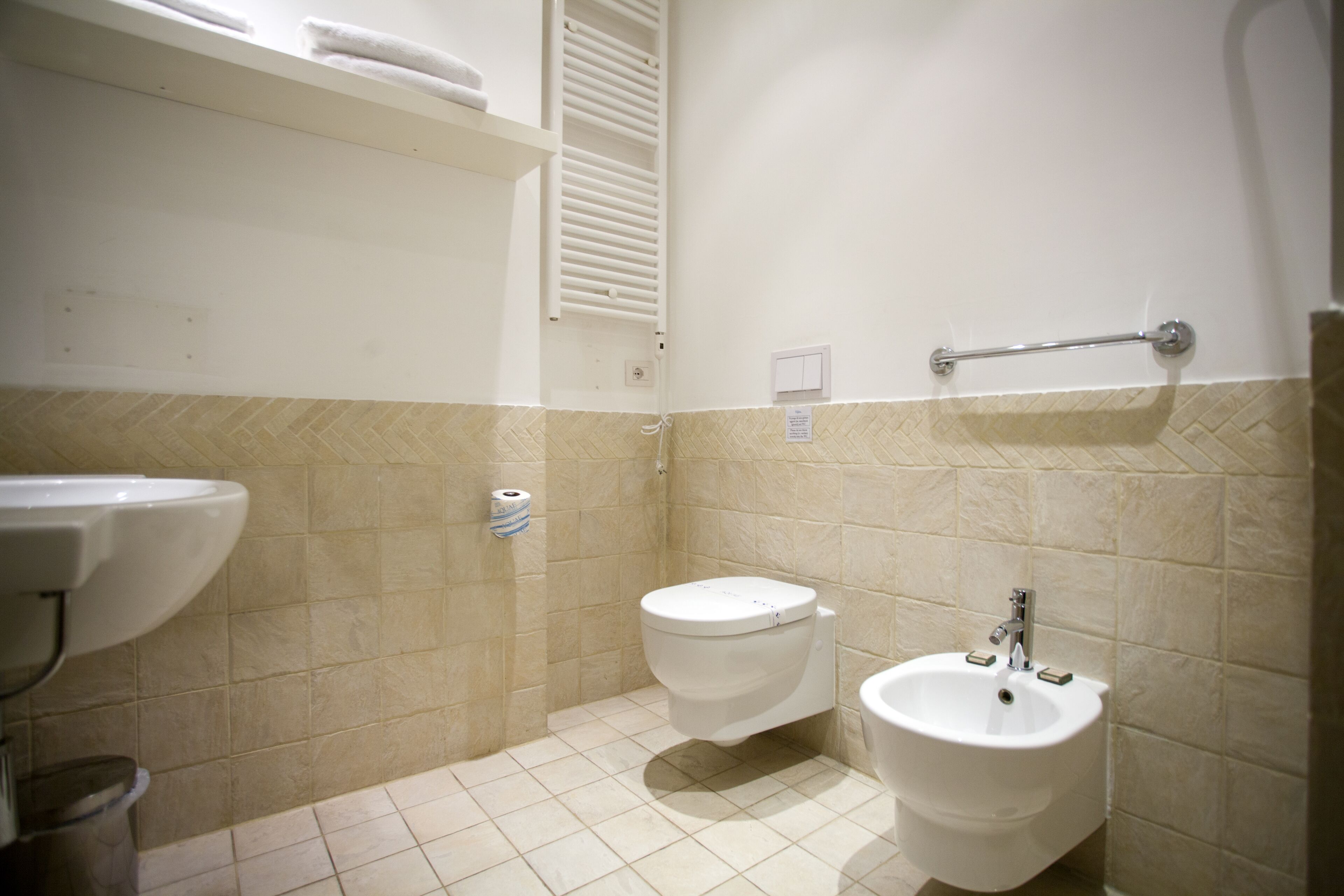 Un baño pequeño con inodoro, bidé y lavamanos.