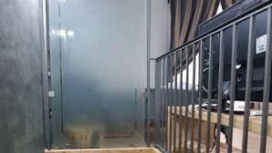 A narrow stairway with a wooden handrail and metal railing, leading to a door at the bottom. - Portanova (Naples)