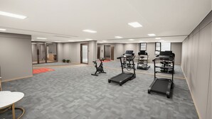A modern fitness room with exercise equipment, a treadmill, an elliptical, and a stationary bike. - Junshan Hotel (Guangzhou)