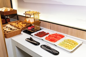 A buffet with various food items and serving utensils.